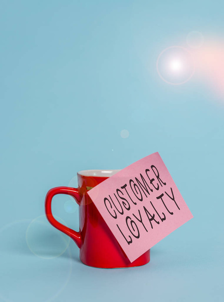 Text sign showing Customer Loyalty. Conceptual photo customers are devoted to a company s is products or services Coffee tea cup mug colored sticky note lying beautiful pastel background. - Photo, Image