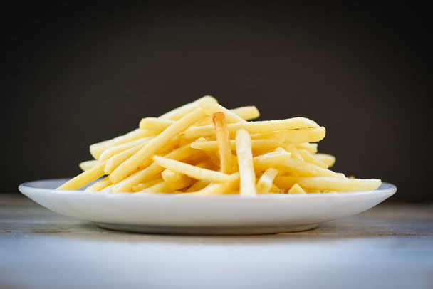 Fresh french fries in white plate with black background - Tasty  - Photo, Image