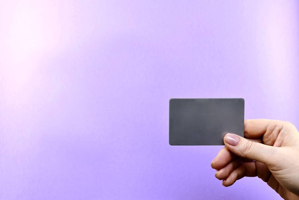  Demonstration of a gray card in a hand on a purple background. - Foto, immagini
