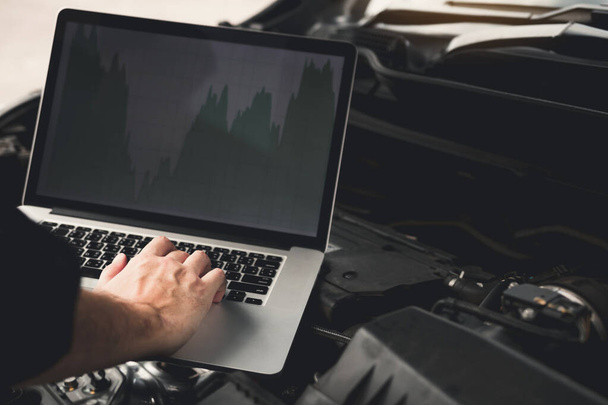 Auton korjaus teknikot käyttävät kannettavia tietokoneita mitata moottorin va
 - Valokuva, kuva