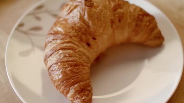 HomeMade croissant on the plate. Stock footage. Delicious croissant on a plate in the pastry shop. Baking croissants home kitchen. Having breakfast concept - Footage, Video