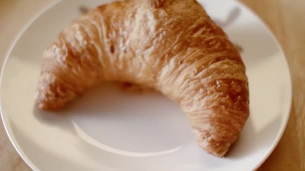 Kotitekoinen croissant lautasella. Varastomateriaalia. Herkullinen croissant leivonnaiskaupan lautasella. Leivon croissantteja kotikeittiössä. Ottaa aamiainen käsite
 - Materiaali, video