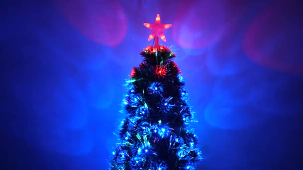 schöner Weihnachtsbaum im Zimmer, geschmückt mit einer leuchtenden Girlande und einem Stern. Neujahrsstimmung 2020. Weihnachtsbaum, frohe Feiertage. Weihnachtsinterieur. Urlaub für Kinder und Erwachsene. - Filmmaterial, Video
