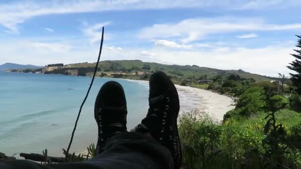 Vista dos pés, pernas viradas para a praia de Karitane em Dunedin, Nova Zelândia
. - Filmagem, Vídeo