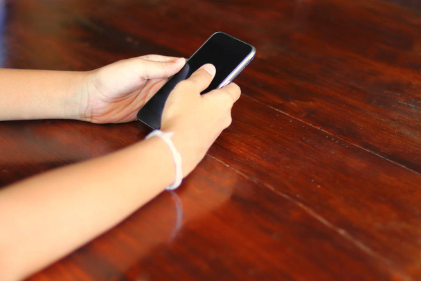 Молодые руки, использующие смартфоны - подростки используют и делятся контентом в социальных сетях с мобильными смартфонами - технологическая концепция с молодым подростком, зависимым от Интернета на мобильных устройствах
 - Фото, изображение
