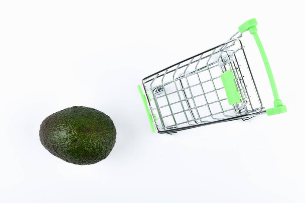 Avokado ticareti konsepti satın almak. İnternetteki mağaza. Beyaz arka planda araba ve avokado. iş konsepti sağlıklı yeme konsepti - Fotoğraf, Görsel