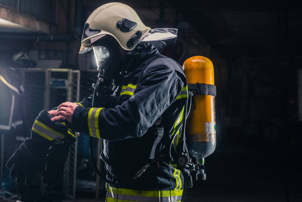 Bombeiro com uniforme protetor usando máscara de oxigênio
 - Foto, Imagem