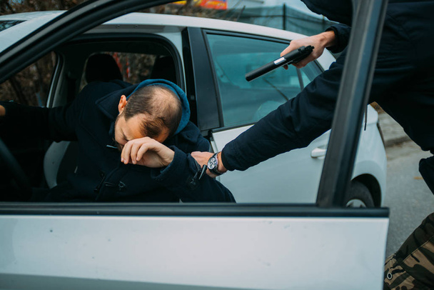 Gangster s pistolí se snaží vyloupit chlapa, který sedí ve svém  - Fotografie, Obrázek