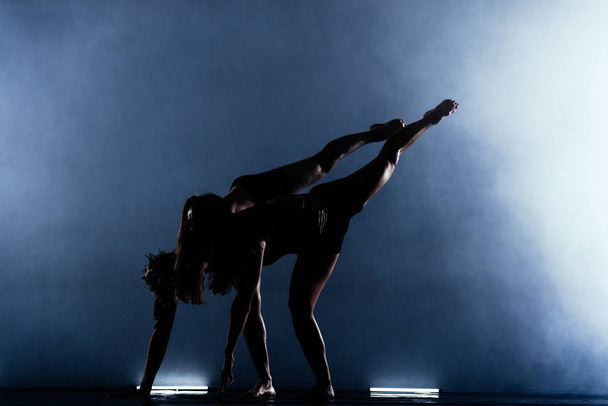 Тонкие партнеры по спортивному танцу в колготках, исполняющие балет в современном стиле - Фото, изображение