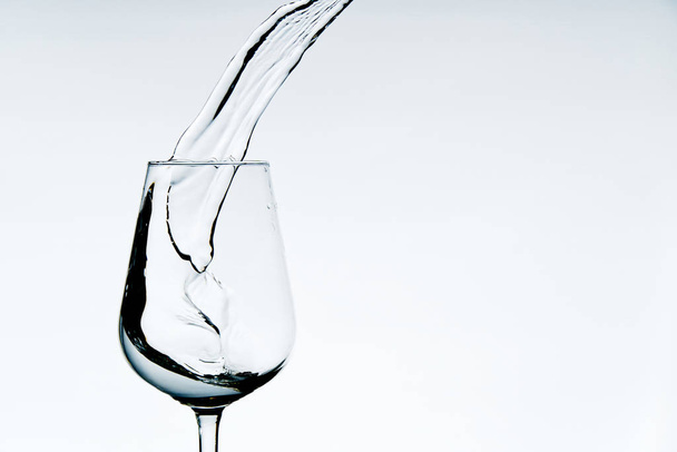 beautiful splashes of water in a wine glass, isolate on white, close up with copy space. - Fotoğraf, Görsel