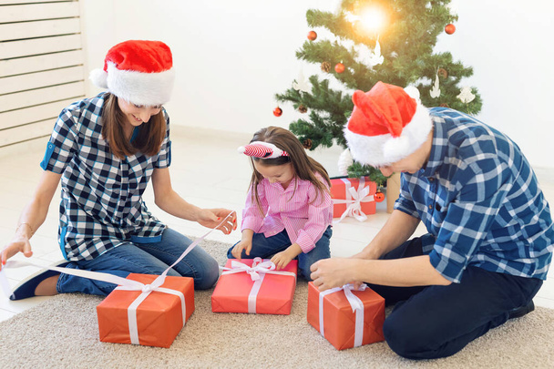 Holidays and presents concept - Portrait of a happy family opening gifts at Christmas time - Photo, Image
