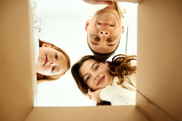白い背もたれの新しい家で段ボール箱をアンパックする家族 - 写真・画像
