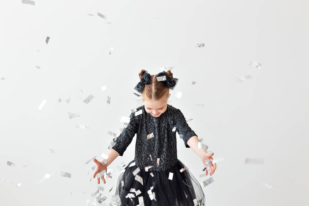 Party, holidays, new year and celebration concept - Female child throwing confetti. - Foto, Bild