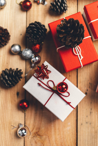 Χριστουγεννιάτικο δώρο, κουκουνάρια και κλαδιά στο ξύλο - Φωτογραφία, εικόνα