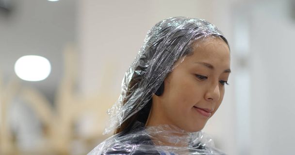 Frau mit Haarbehandlung wartet im Schönheitssalon - Foto, Bild