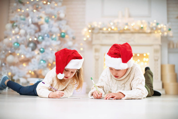 two children write a letter with wishes for the new year - 写真・画像