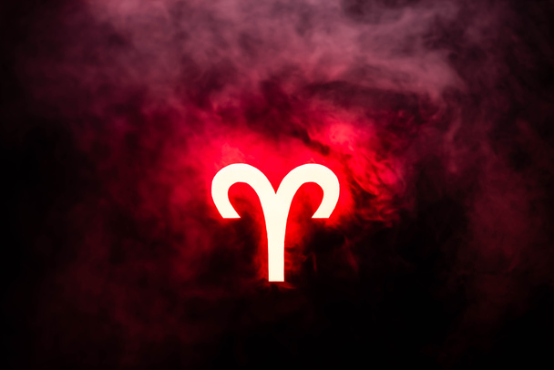 rosso illuminato segno zodiacale Ariete con fumo sullo sfondo
 - Foto, immagini