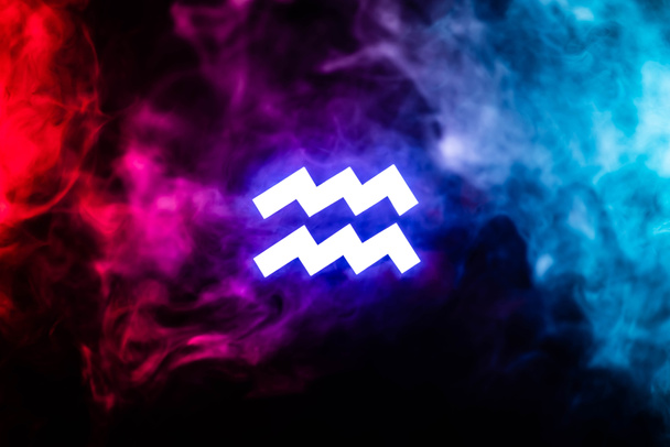 blau beleuchtetes Tierkreiszeichen Wassermann mit buntem Rauch auf Hintergrund - Foto, Bild