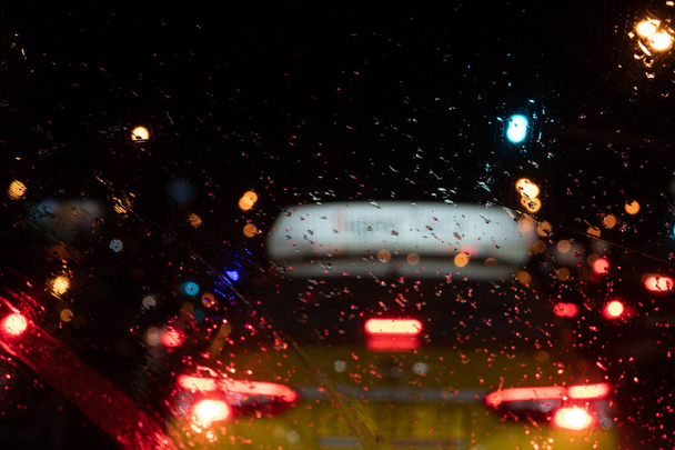 Οδήγηση σε αντανακλάσεις βροχής των προβολέων ενός αυτοκινήτου το βράδυ τη διαχείριση ενός αυτοκινήτου σε μια θέα στη βροχή ενός ταξί - Φωτογραφία, εικόνα