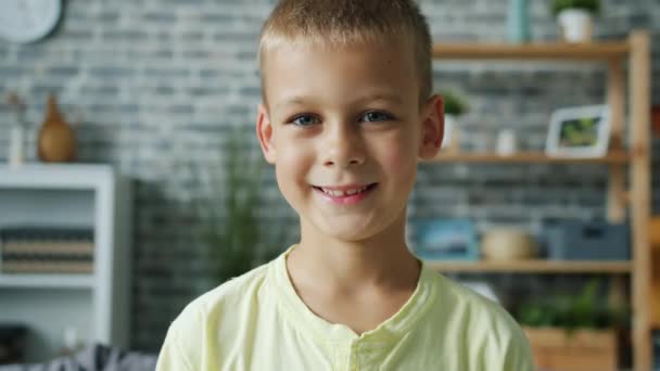 Close-up portrait of sweet child small boy smiling standing in apartment alone - Imágenes, Vídeo