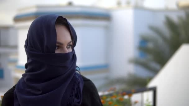 Jeune femme en burqa arabe. Une femme regarde la caméra. Dans le contexte de la maison arabe. - Séquence, vidéo