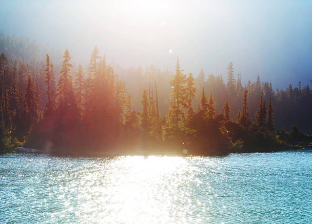 Escena serena junto al lago de montaña con reflejo de las rocas en el agua tranquila. - Foto, Imagen