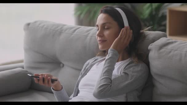 Calm carefree millennial mixed race girl enjoying favorite pop music. - Filmmaterial, Video