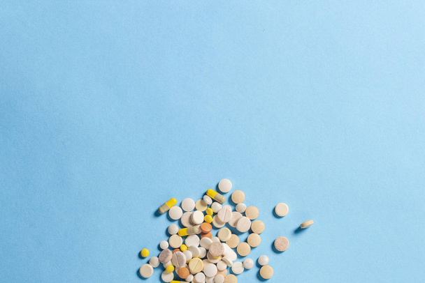 A lot of pills of different types on a blue background. Insomnia, taking pills according to the regimen, vitamins. Flat lay, top view - Foto, Imagen
