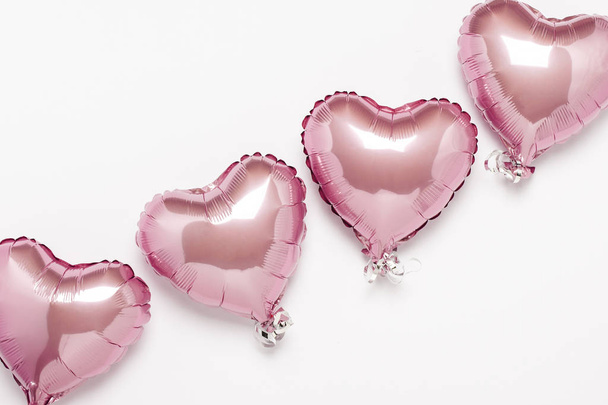 Globos de aire rosa en forma de corazón sobre un fondo blanco. Boda conceptual, día de San Valentín, zona de fotos, amantes. Banner. Piso tendido, vista superior - Foto, Imagen