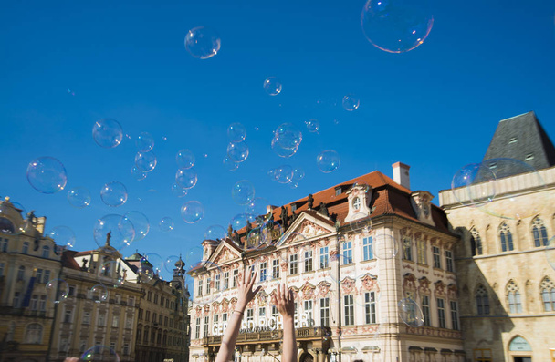 PRAGUE, CZECH REPUBLIC - JUNE 01 Unidentified young woman makes soap bubbles in Old Town Square (Staromestske namesti) in Prague, Czech Republic - Foto, Imagen