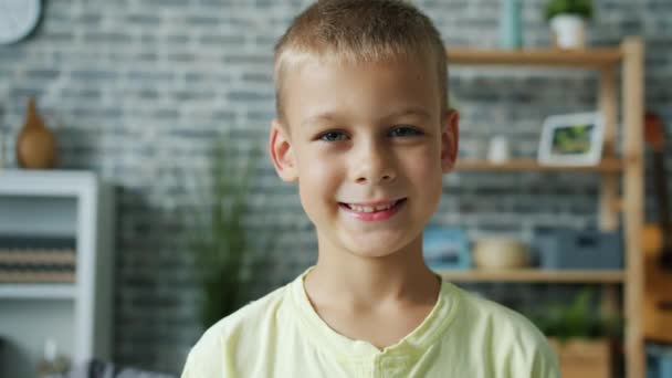 Slow motion portrait of cute little boy with fair hair looking at camera smiling - Metraje, vídeo