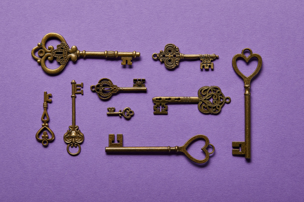 top view of vintage keys on violet background - Foto, afbeelding