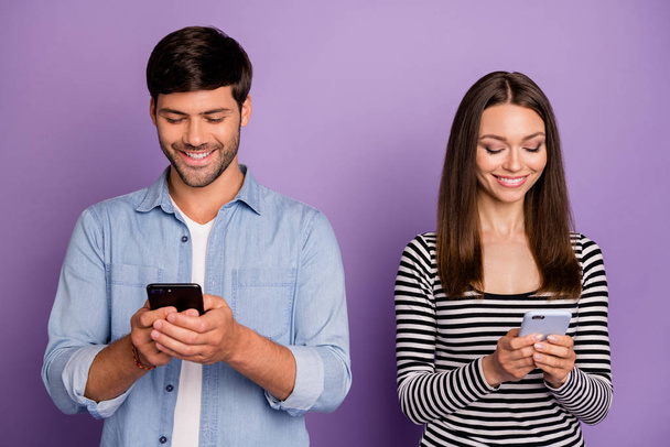 Fénykép két ember pár fickó hölgy gazdaság telefonok számlálás szereti a követők reposts részvények függő közösségi hálózat felhasználók viselnek alkalmi ruhát elszigetelt lila színű háttér - Fotó, kép
