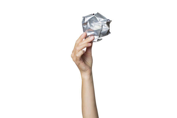 La mano femenina sostiene una lata arrugada sobre un fondo blanco aislado. El concepto de basura separada, plástico de parada, reciclaje
 - Foto, imagen