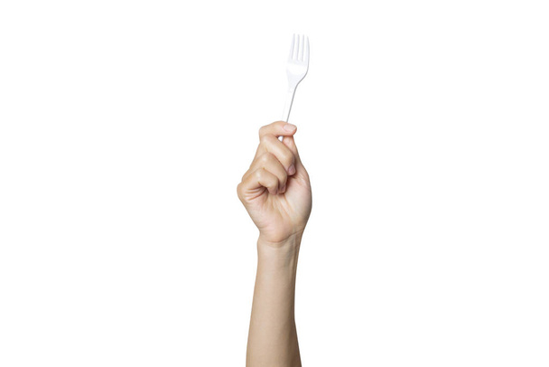 Vrouwelijke hand houdt een plastic vork op een witte geïsoleerde achtergrond. Het concept van gescheiden afval, stop plastic, recycling - Foto, afbeelding