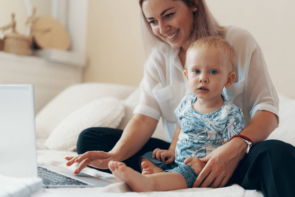 Moderní žena pracující s dítětem. Multi-tasking, freelance a mateřství koncept - Fotografie, Obrázek