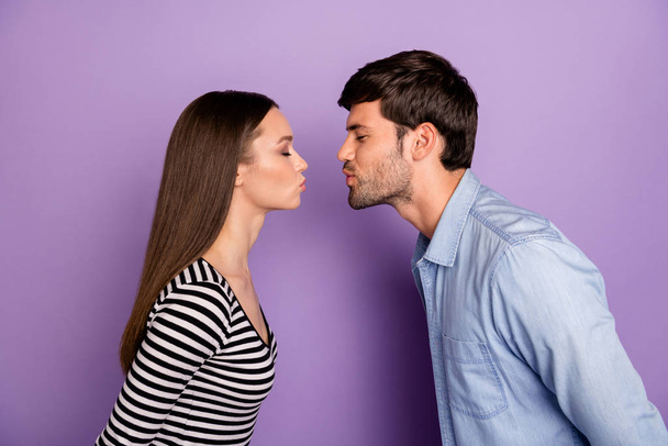 Profile photo of two people couple guy lady standing opposite eyes closed romance moment kissing affectionate wear stylish casual outfit isolated pastel purple color background - Valokuva, kuva