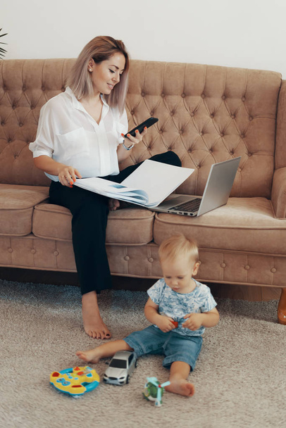 Όμορφη επιχειρηματίας που δουλεύει στο σπίτι. Multi-tasking, freelance και έννοια της μητρότητας - Φωτογραφία, εικόνα