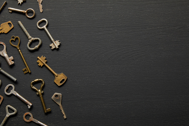 top view of vintage rusty keys on black background - Foto, imagen