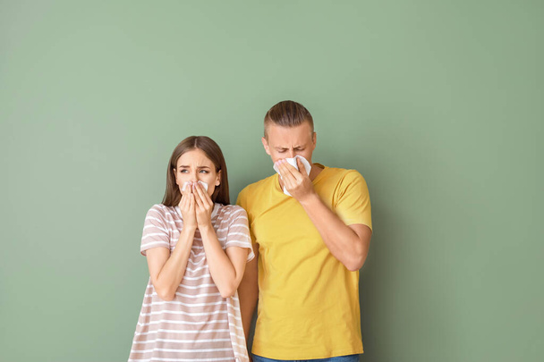 Jong paar dat lijdt aan allergie op kleur achtergrond - Foto, afbeelding