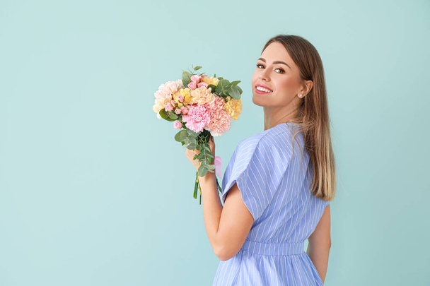 Красива молода жінка з букетом з квітів гвоздик на кольоровому фоні
 - Фото, зображення
