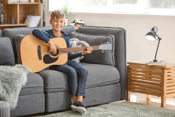 Little boy playing guitar at home - 写真・画像