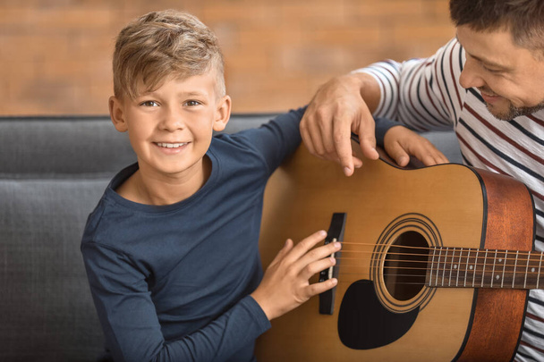 Ojciec i jego synek z gitarą w domu - Zdjęcie, obraz