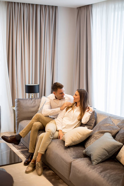 若いカップルの豪華なリビング ルームのソファでリラックス - 写真・画像