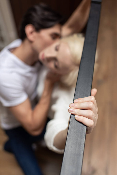 Balkon korkuluklarında sevgiliyi öpen adamın seçici odağı - Fotoğraf, Görsel