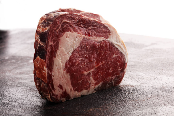 Raw fresh meat Ribeye Steak, seasoning and meat fork on rustic b - Photo, Image