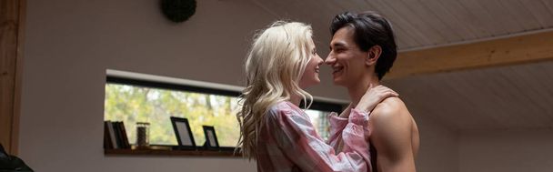 Panoramic shot of young couple smiling at each other at home - Foto, Imagem