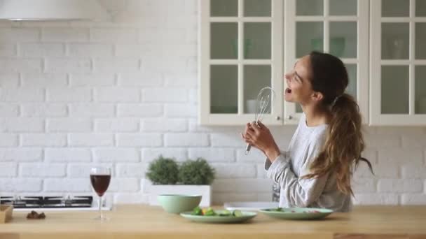 Mujer feliz cantando en el micrófono batidor bailando cocina en casa
 - Imágenes, Vídeo