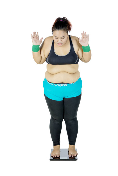 Fat Asian woman measuring her body weight - Foto, imagen