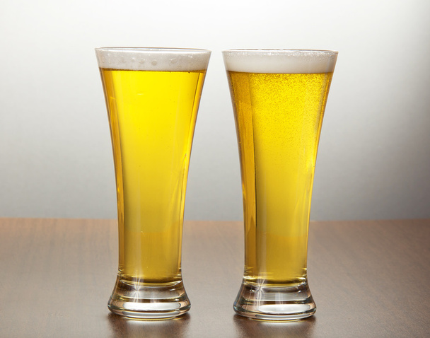 灰色の背景に新鮮なビールを 2 杯 - 写真・画像